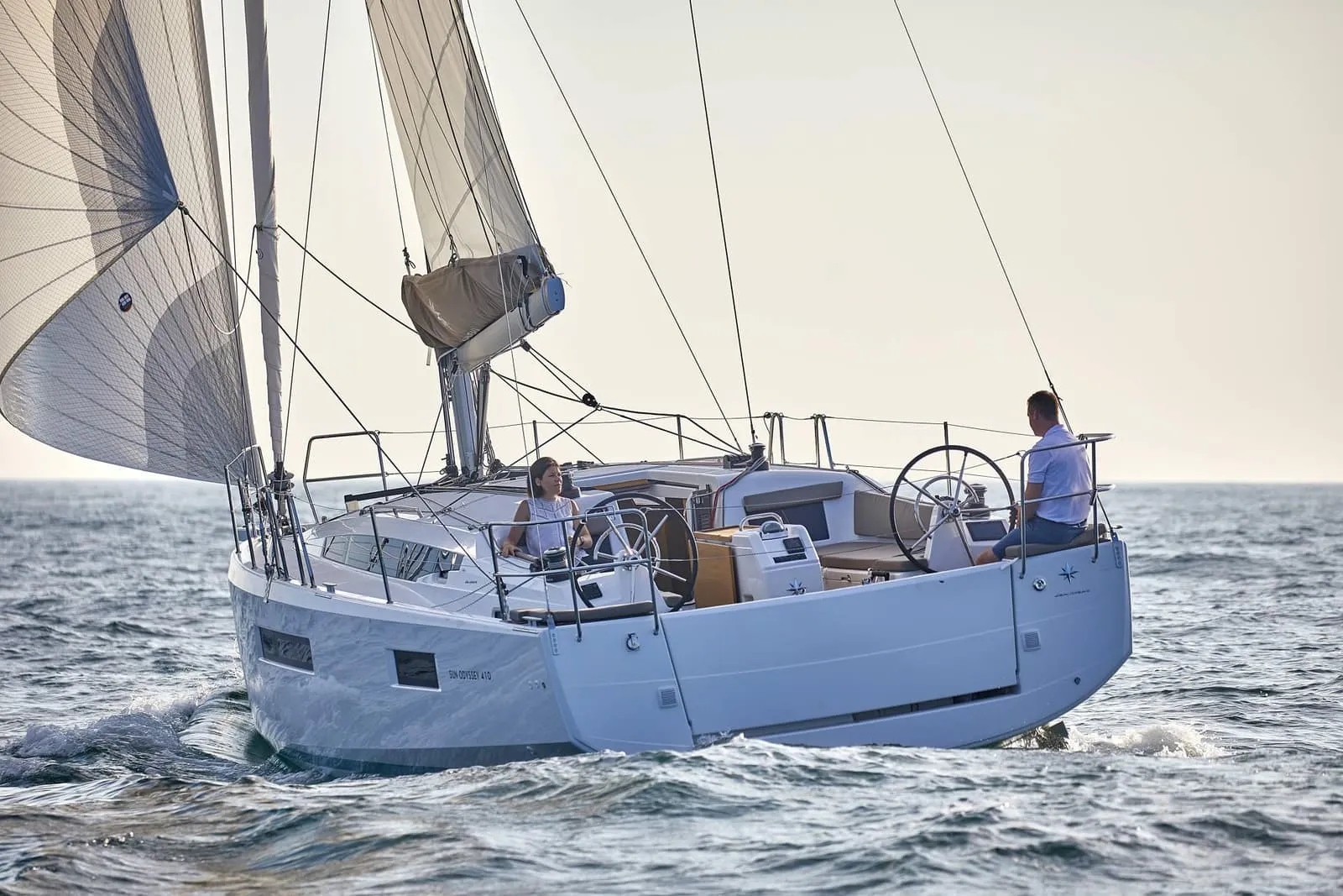 A family sailing a yacht in the sunshine